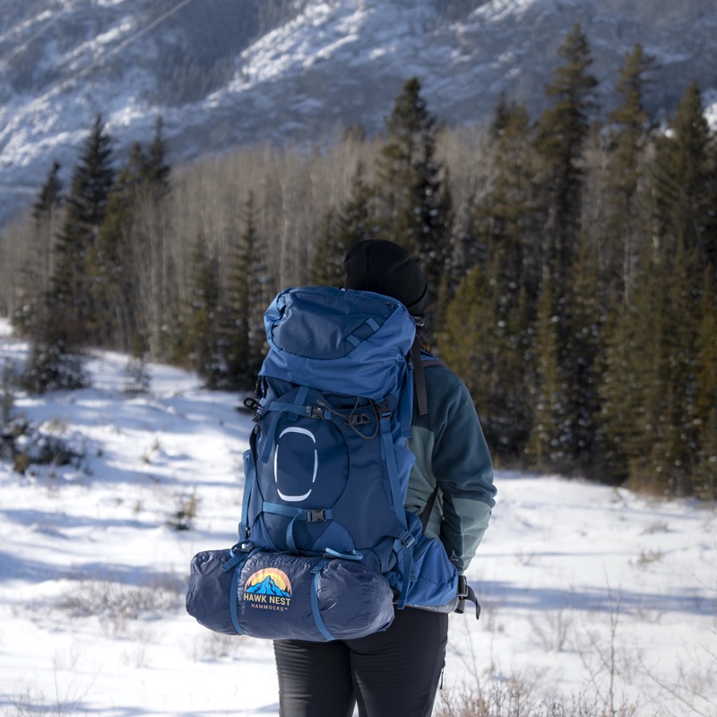 Hiker with Hawk Nest backpack in winter mountains